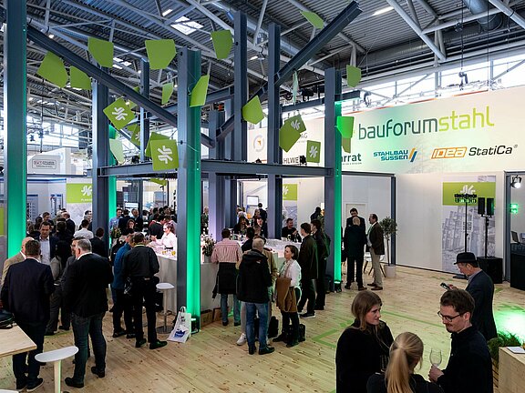 Messestand von Bauforumstahl, umgesetzt von Holtmann+, in einer Messehalle in München 2023 auf der Messe BAU.