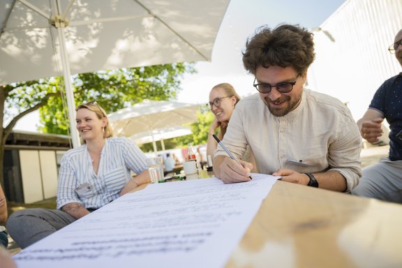 Mitarbeiter von Holtmann+ schreibt etwas auf einen Zettel