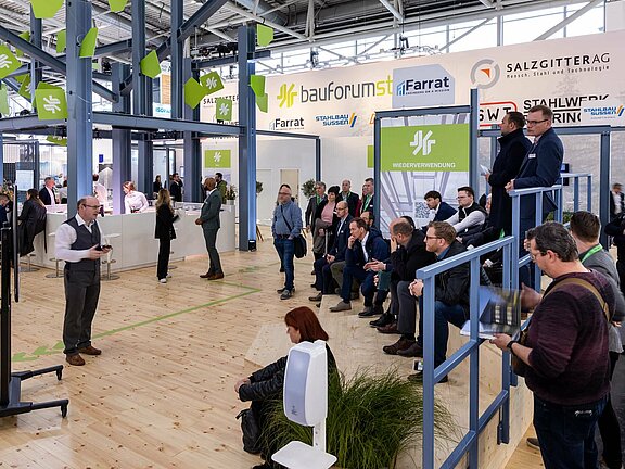 Messestand von Bauforumstahl, umgesetzt von Holtmann+, in einer Messehalle in München 2023 auf der Messe BAU.