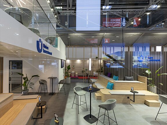 Messestand von DZ HYP und Union Investment, umgesetzt von Holtmann+, in einer Messehalle in München 2023 auf der Messe Expo Real.