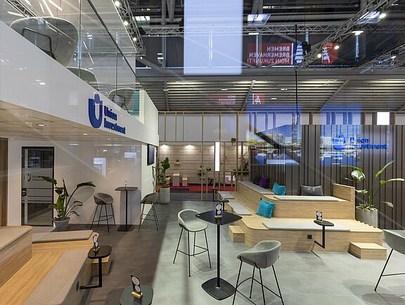 Messestand von DZ HYP und Union Investment, umgesetzt von Holtmann+, in einer Messehalle in München 2023 auf der Messe Expo Real.