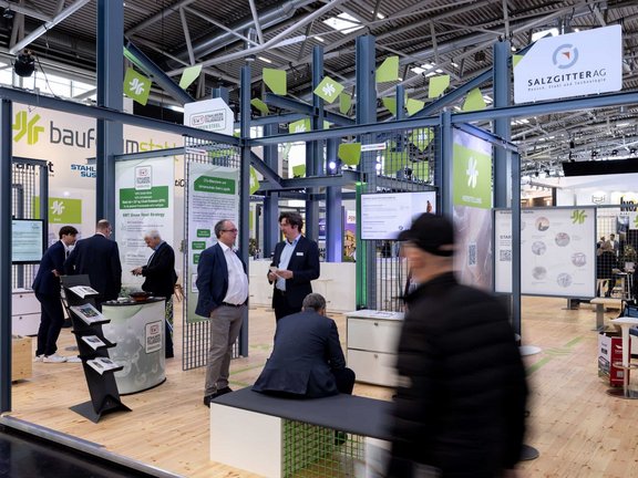 Messestand von Bauforumstahl, umgesetzt von Holtmann+, in einer Messehalle in München 2023 auf der Messe BAU.