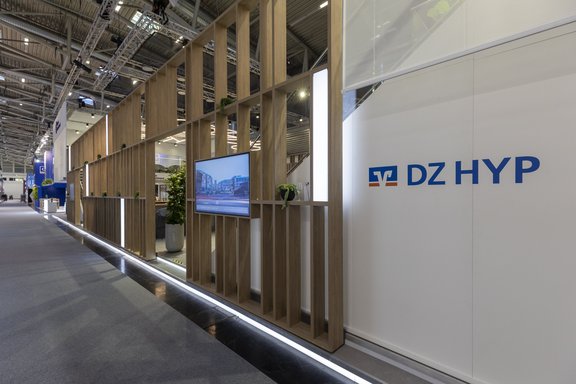 Messestand von DZ HYP und Union Investment, umgesetzt von Holtmann+, in einer Messehalle in München 2023 auf der Messe Expo Real.
